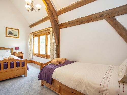 a bedroom with two beds and a window at Pondmead in Monk Okehampton