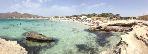 a beach with a bunch of people in the water at Le Casuzze del Residence Lido Burrone in Favignana