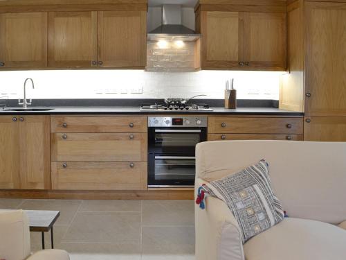 a kitchen with wooden cabinets and a stove top oven at The Mill in Tregaron