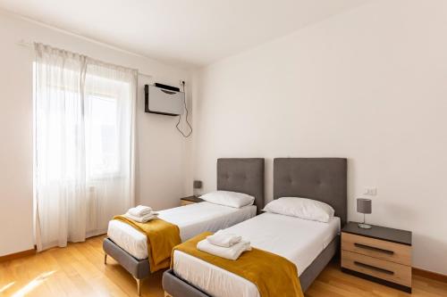 ein Schlafzimmer mit zwei Betten und einem Fenster in der Unterkunft GuestHost - Ponte Vecchio Charming Apartments in Florenz