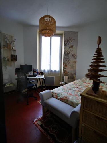 a bedroom with a bed and a desk with a computer at Chambres à St Loup-Marseille in Marseille