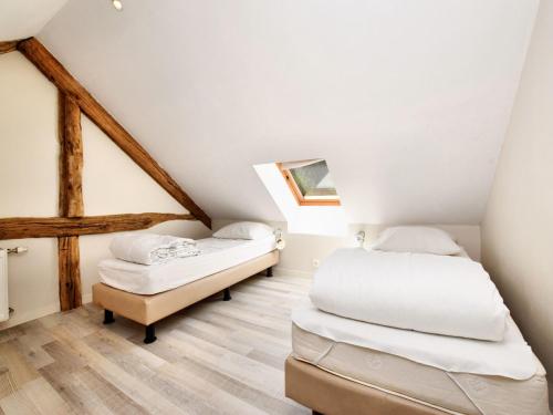 two beds in a room with wooden floors at Fine group house with sauna garden in Chiny