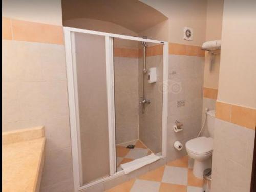 a bathroom with a shower and a toilet at JAZ Makadi Saraya Resort in Hurghada