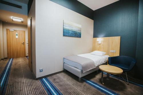a room with a bed and a table and a chair at Hotel Radocza Park Business in Radocza