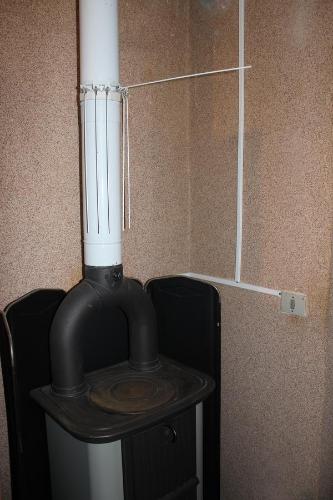 a black stove with a white pipe on a wall at Casa Gemei in Mello