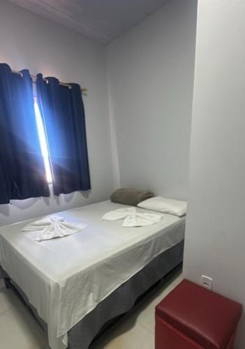a room with two beds and a red stool at Hotel Porto Sollar in Porto Nacional