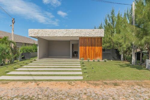a house with an orange door in a yard at Summerville #269 - Casa em Cumbuco by Carpediem in Caucaia