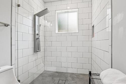 a bathroom with a white tiled shower with a window at The Ultimate View House in Dallas