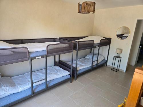 three bunk beds in a room with a mirror at Chez Monique - Mur de Sologne - 8 personnes in Mur-de-Sologne