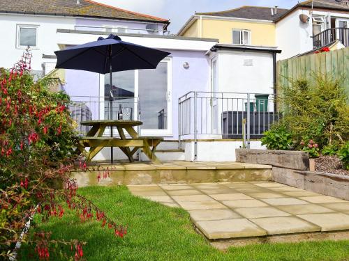 a picnic table with an umbrella in a yard at Buckingham Cottage in Ventnor