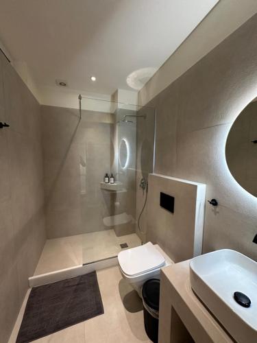 a bathroom with a white toilet and a sink at DIONE Suite in Ermoupoli