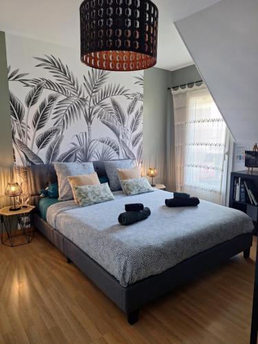 a bedroom with a large bed with two black hats on it at Chambre climatisée au cœur de brive avec téléviseur connecté wifi Netflix in Brive-la-Gaillarde