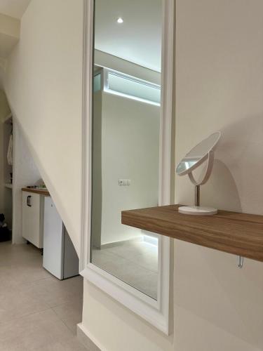 a glass door with a lamp on a wooden shelf at DIONE Suite in Ermoupoli
