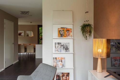 a living room with a chair and a lamp at Dutchen Villapark Mooi Schoorl in Schoorl