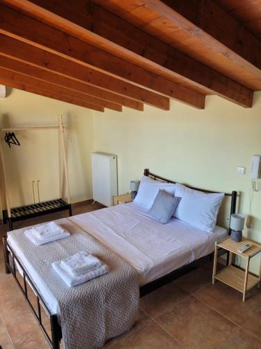 a bedroom with a large bed with two towels on it at Lovely house with amazing views in Kánithos