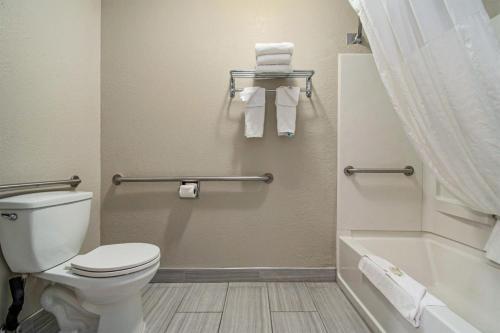 a bathroom with a toilet and a bath tub at Days Inn & Suites by Wyndham Mt Pleasant in Mount Pleasant
