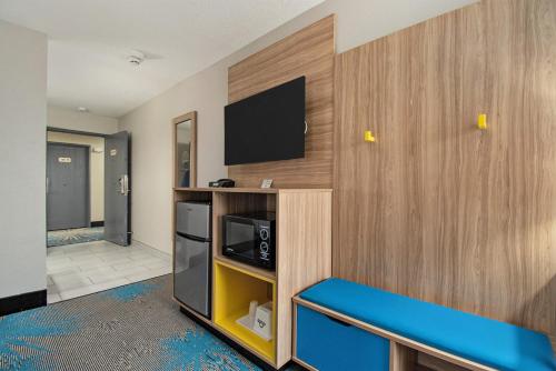 a room with a tv on a wall at Days Inn & Suites by Wyndham Mt Pleasant in Mount Pleasant