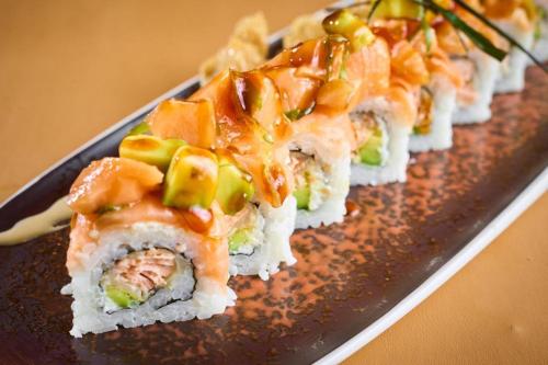 a row of sushi on a black plate at Hotel Manantial Valencia in Valencia