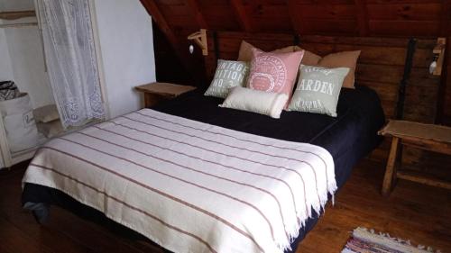 a bedroom with a bed with pink and white pillows at Cabaña,Chalet Alpino Bosques de Peralta Ramos in Mar del Plata