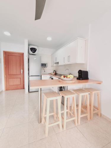 a kitchen with a table and some stools in it at Pambnb - Sal Marina in Güimar