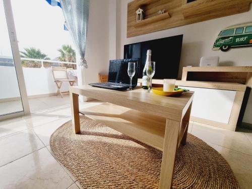 a wooden table with a laptop on it in a living room at Pambnb - Sal Marina in Güimar