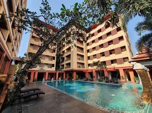 a large hotel with a swimming pool in front of a building at Palette Luxe North Pattaya in Pattaya North