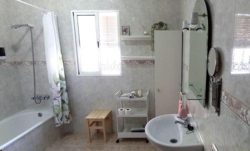 a white bathroom with a sink and a tub and a sink at Casa Paco & Carmela in Algodonales