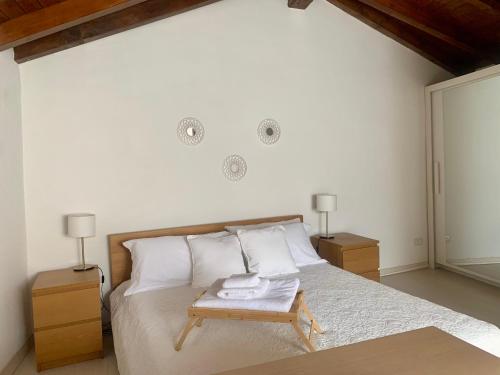 a bedroom with a bed with a table with towels on it at Indipendent House in the historical city center in Varese