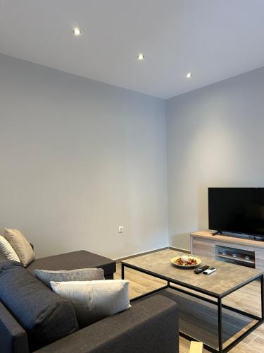 a living room with a couch and a tv at MtsHome in Áyios Spirídhon