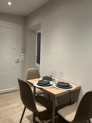 a dining room table with chairs and wine glasses at MtsHome in Áyios Spirídhon