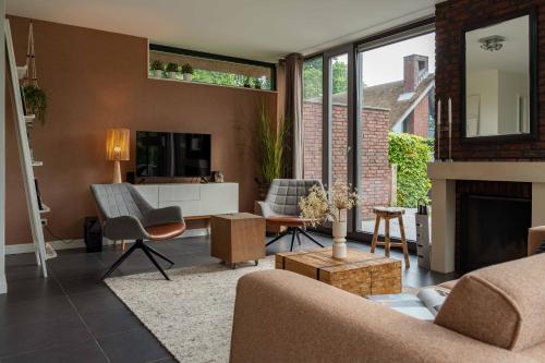 a living room with a couch and a fireplace at Dutchen Villapark Mooi Schoorl in Schoorl