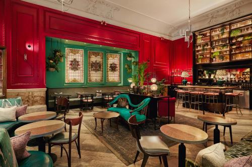 a restaurant with red walls and tables and a bar at Andaz London Liverpool Street, By Hyatt in London
