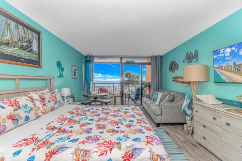 - une chambre avec des murs bleus, un lit et un canapé dans l'établissement Beautiful 2nd Floor Oceanfront Studio w King Bed! Landmark 229, à Myrtle Beach