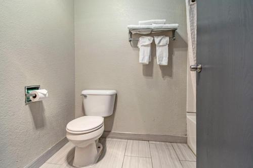 a bathroom with a toilet and towels in it at Days Inn & Suites by Wyndham Mt Pleasant in Mount Pleasant
