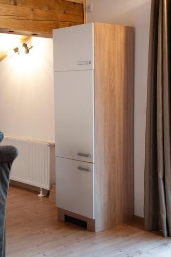 a white refrigerator in a room with a wooden wall at Haus Kärnten in Döbriach