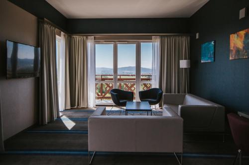 a living room with a couch and chairs in front of a window at Hotel Radocza Park Business in Radocza