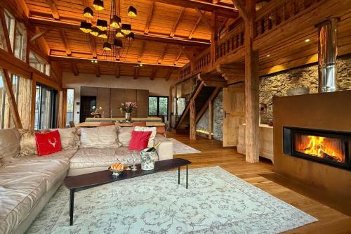 a living room with a couch and a fireplace at DER ERLACHER Alpenrefugium 1874 LUXERY & PRIVACY by Belle-Stay in Jochberg