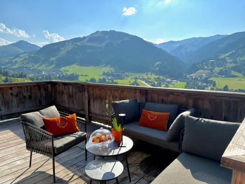 a balcony with couches and a table with a view of mountains at DER ERLACHER Alpenrefugium 1874 LUXERY & PRIVACY by Belle-Stay in Jochberg