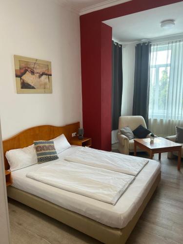 a bedroom with a large bed and a chair at Hotel - Restaurant Zur Linde in Wöllstein