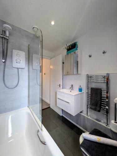 a bathroom with a tub and a sink and a shower at Cottage by historical dockyard in Portsmouth