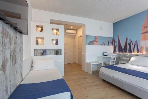 ein Schlafzimmer mit zwei Betten und einem Schreibtisch in der Unterkunft Hotel Negretto in Caorle