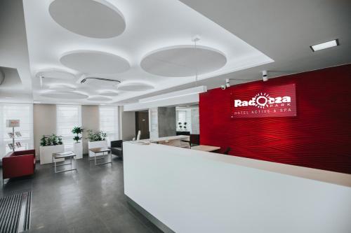 an office with a red wall and a reception counter at Hotel Radocza Park Business in Radocza