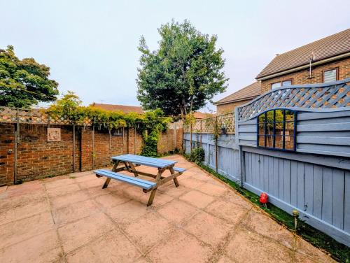 a blue picnic table in the backyard of a house at Cottage by historical dockyard in Portsmouth