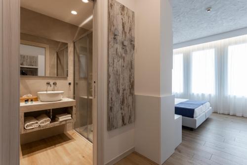 ein Badezimmer mit Waschbecken und Spiegel in der Unterkunft Hotel Negretto in Caorle