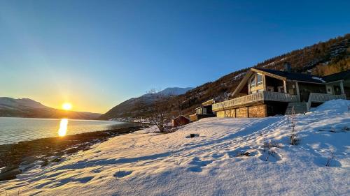a house on the shore of a lake in the snow at Villa Sjøsiden in Lii