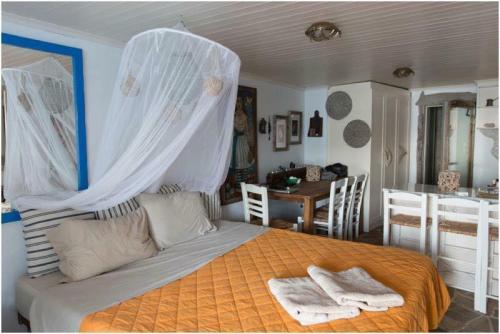 - une chambre avec un lit à baldaquin dans l'établissement Studio Paradiso, à Plaka Milou