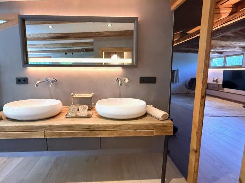 a bathroom with two sinks and a large mirror at DER ERLACHER Alpenrefugium 1874 LUXERY & PRIVACY by Belle-Stay in Jochberg