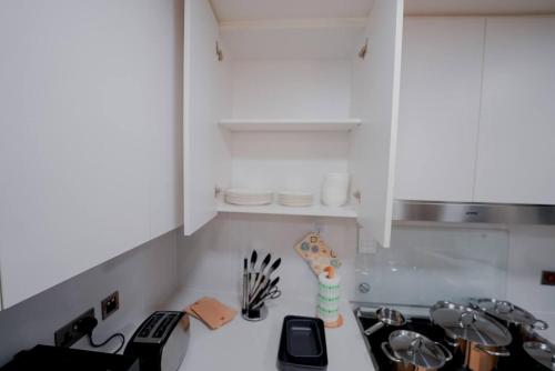 a kitchen with white cabinets and a counter top at Yas Island Villa 4br Smart Luxury-near Yas Parks in Abu Dhabi