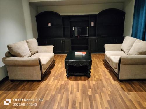 a living room with two couches and a coffee table at City Point Hotel in Manama