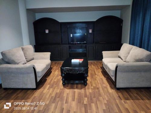 a living room with two couches and a coffee table at City Point Hotel in Manama